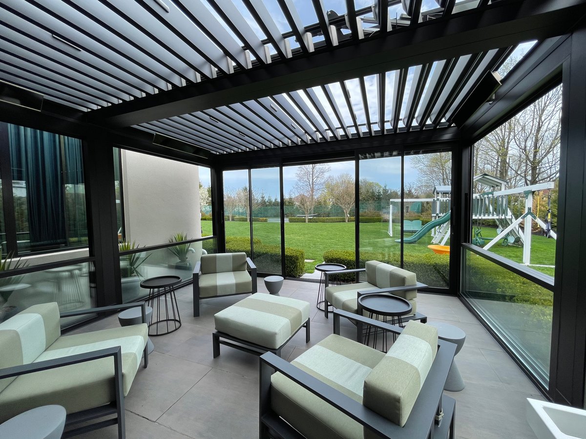  A patio featuring a guillotine glass door and chairs, with a glass wall providing a clear view of the outdoors
