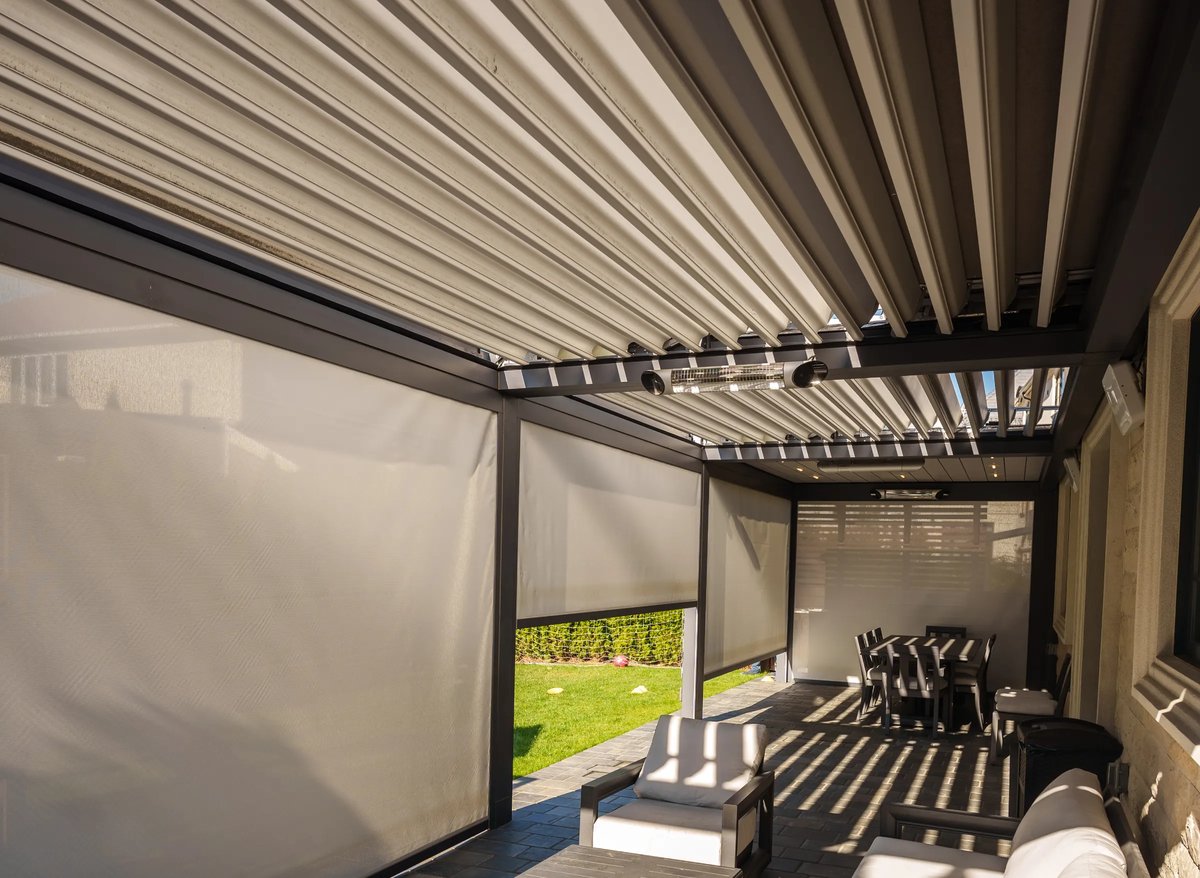 A refined patio showcasing outdoor furniture and sunshades, accompanied by a louvered pergola