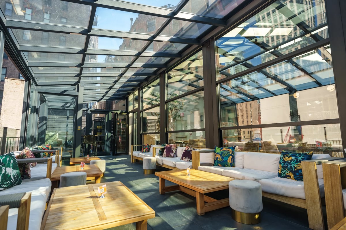 Sunroom pergola in the restaurant with many sofas and tables