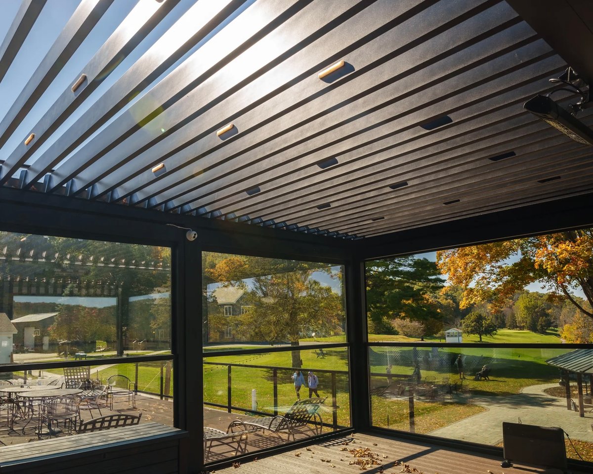 Louvered pergola with open shutters with sunbeams breaking through