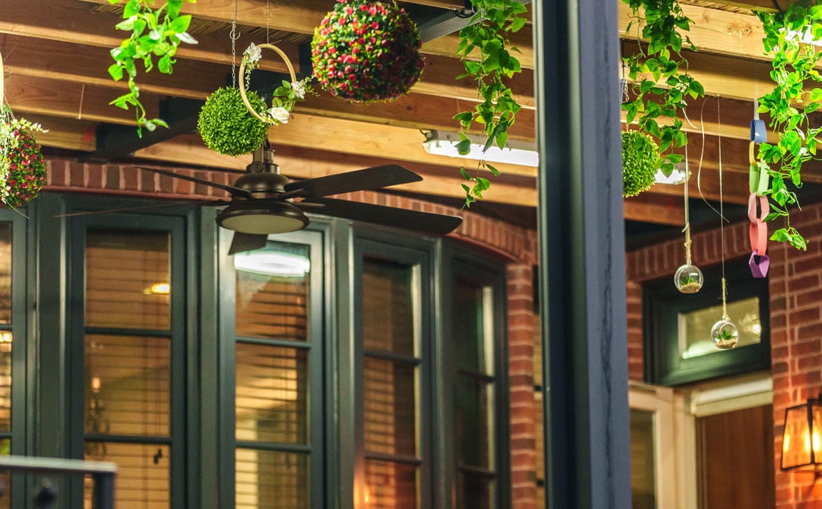 A Sukkah decoration pergola featuring a patio adorned with plants hanging from the ceiling