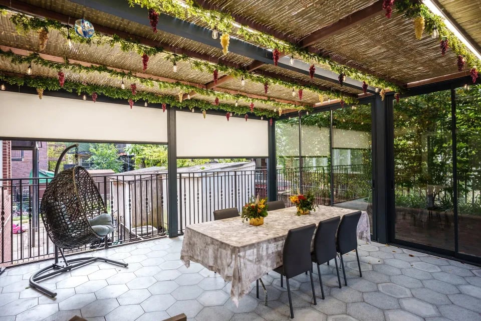 A sukkah, a temporary outdoor dining area, featuring a table and chairs under a covered patio