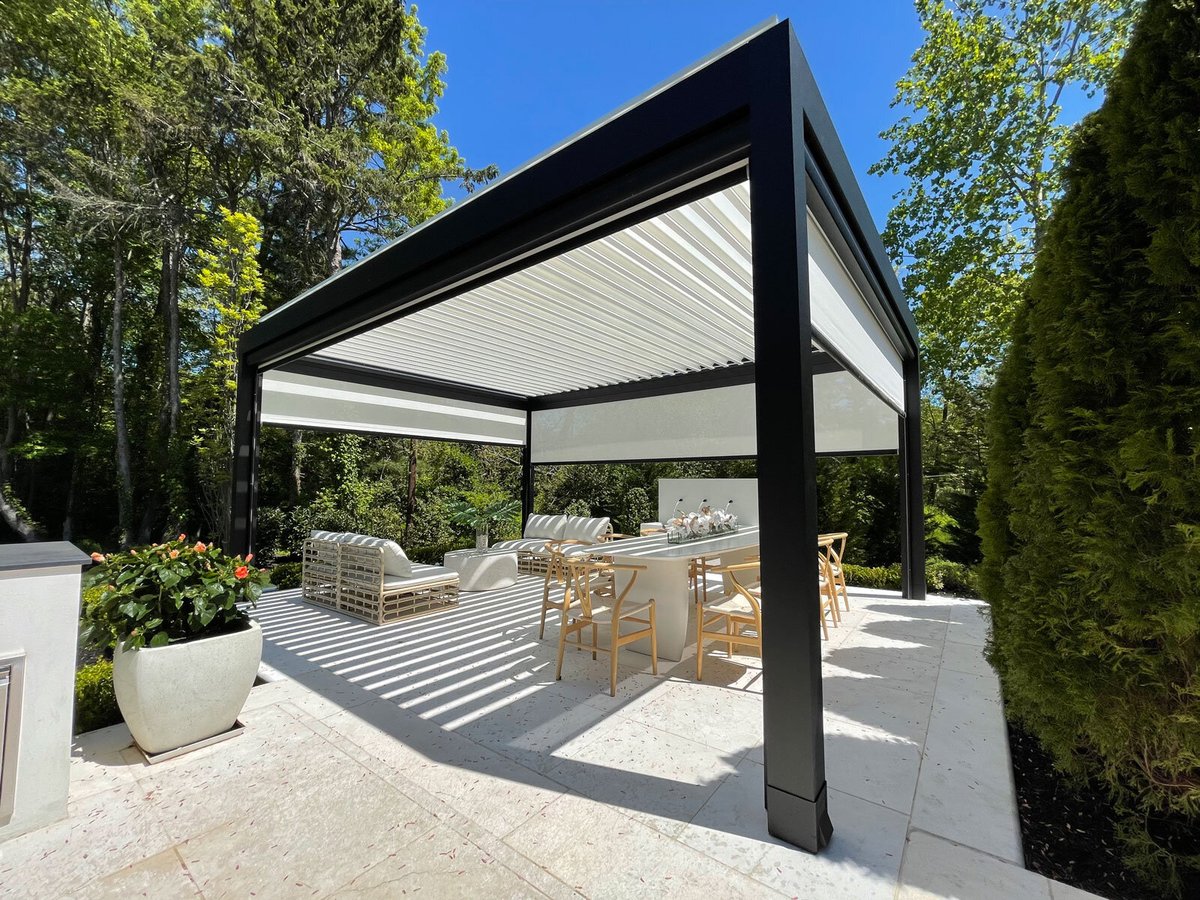 A louvered pergola with table and chairs