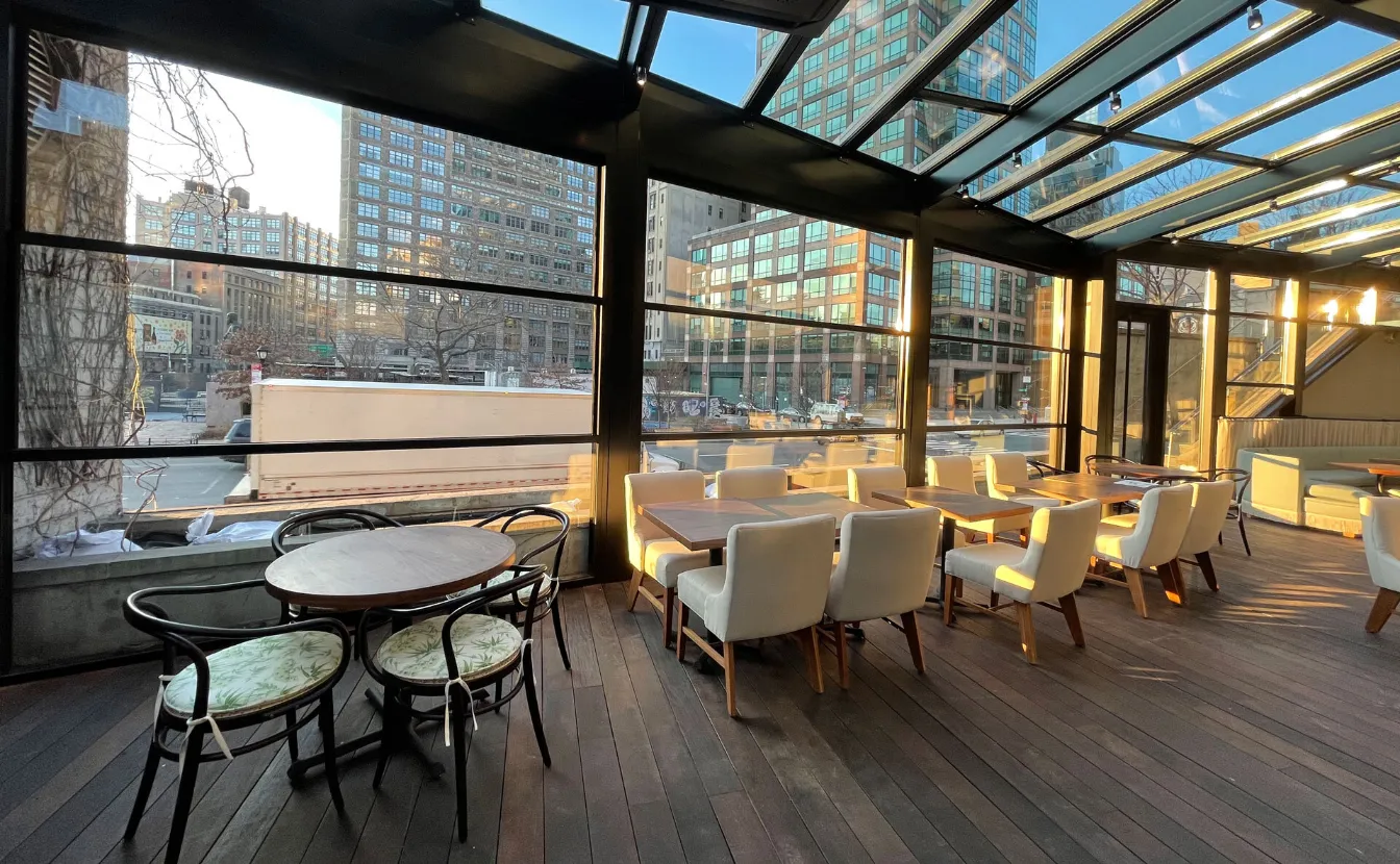 Featured image: A guillotine glass door in a restaurant with a vertical sliding mechanism - Read full post: Guillotine Glass: The Perfect Solution for Pergola Sunrooms