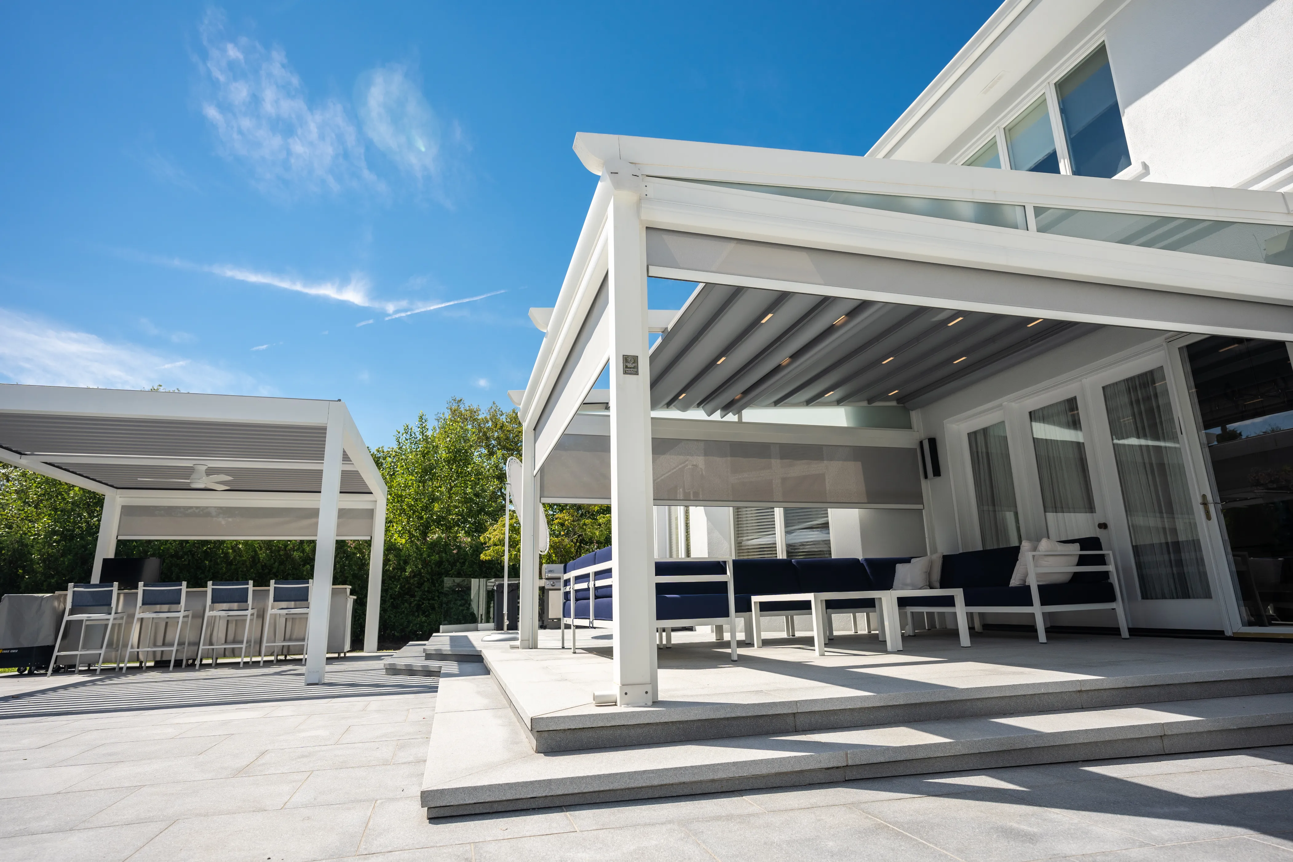 Featured image: A beautifully designed pergola in the backyard of a home, providing shaded outdoor space for relaxation and social gatherings - Read full post: The Ultimate Outdoor Living Experience: Adding a Motorized Pergola to Your Home