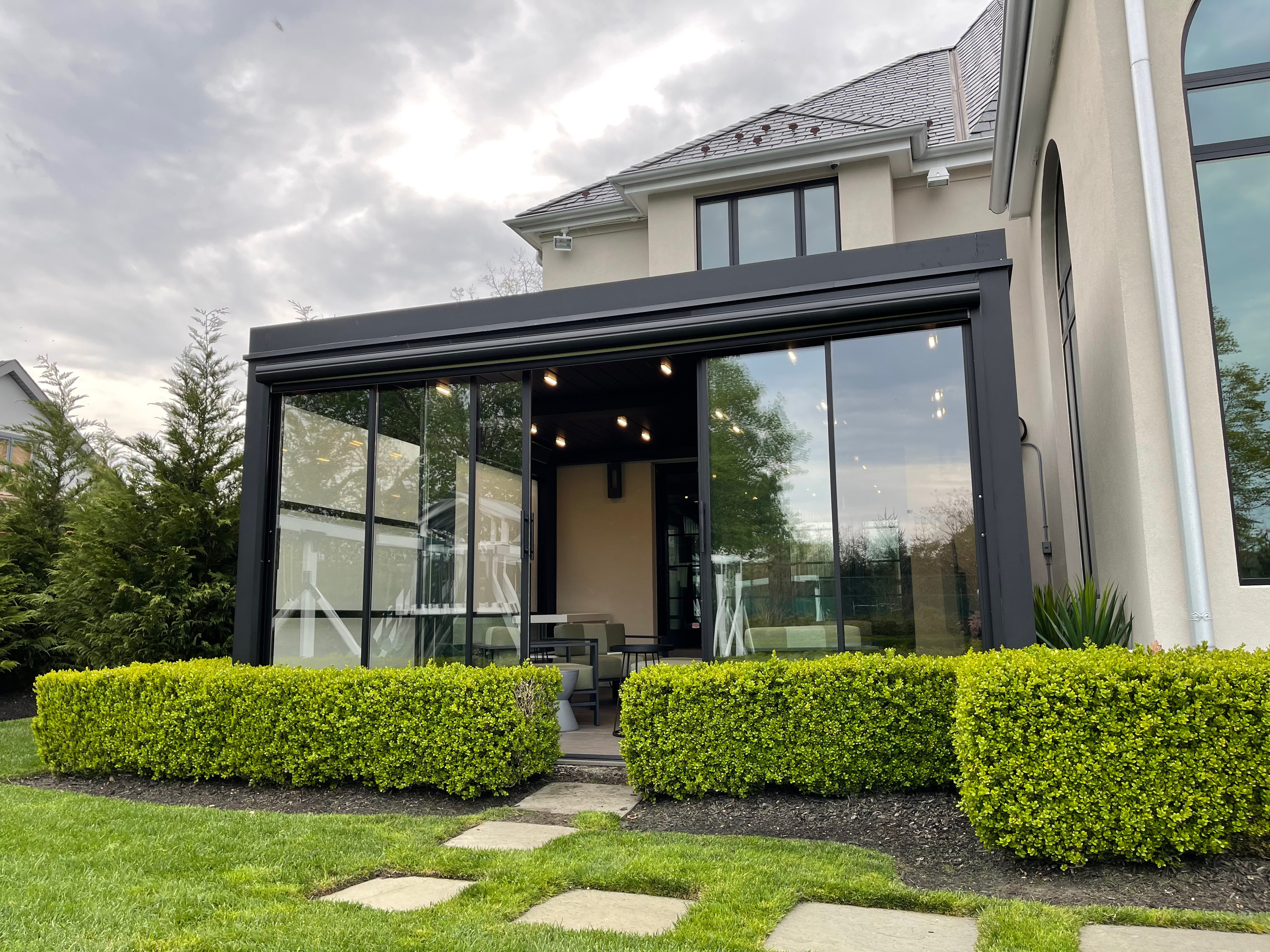 Featured image: A patio with a table and chairs enclosed in glass, featuring a guillotine door for easy access - Read full post: Elevate Your Home's Aesthetic with Guillotine Glass Doors