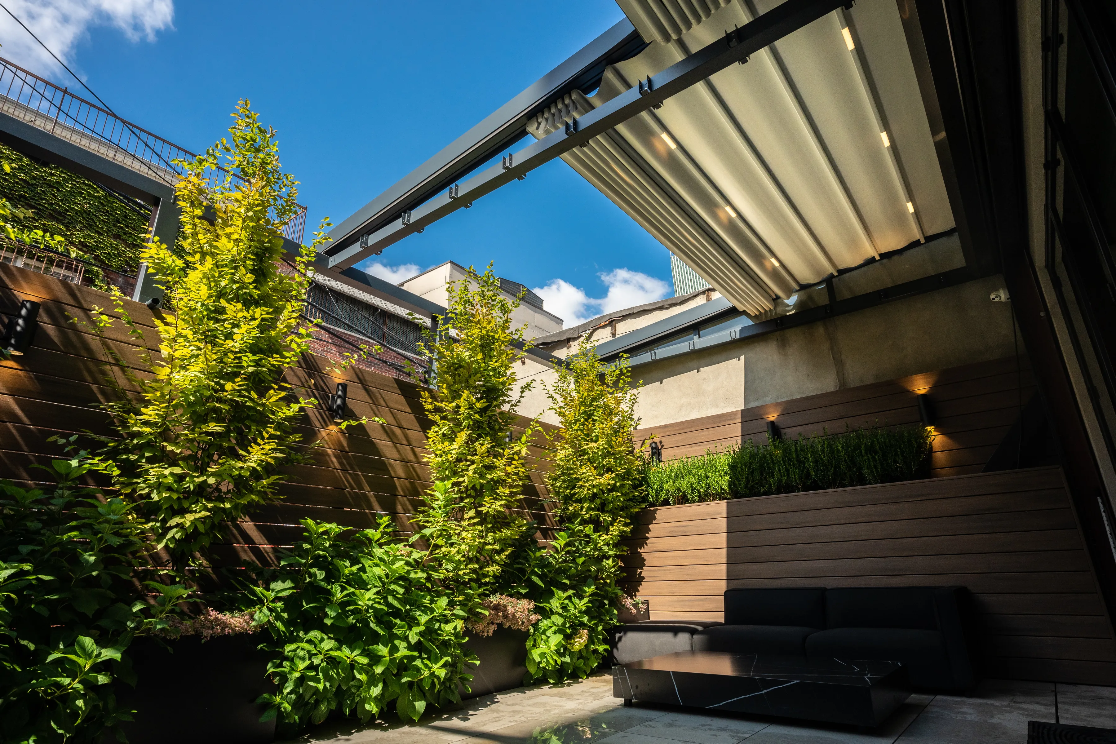 Featured image: Half-open Pergola in the backyard of the house - Read full post: Transforming Your Backyard with a Pergola and Retractable Roof