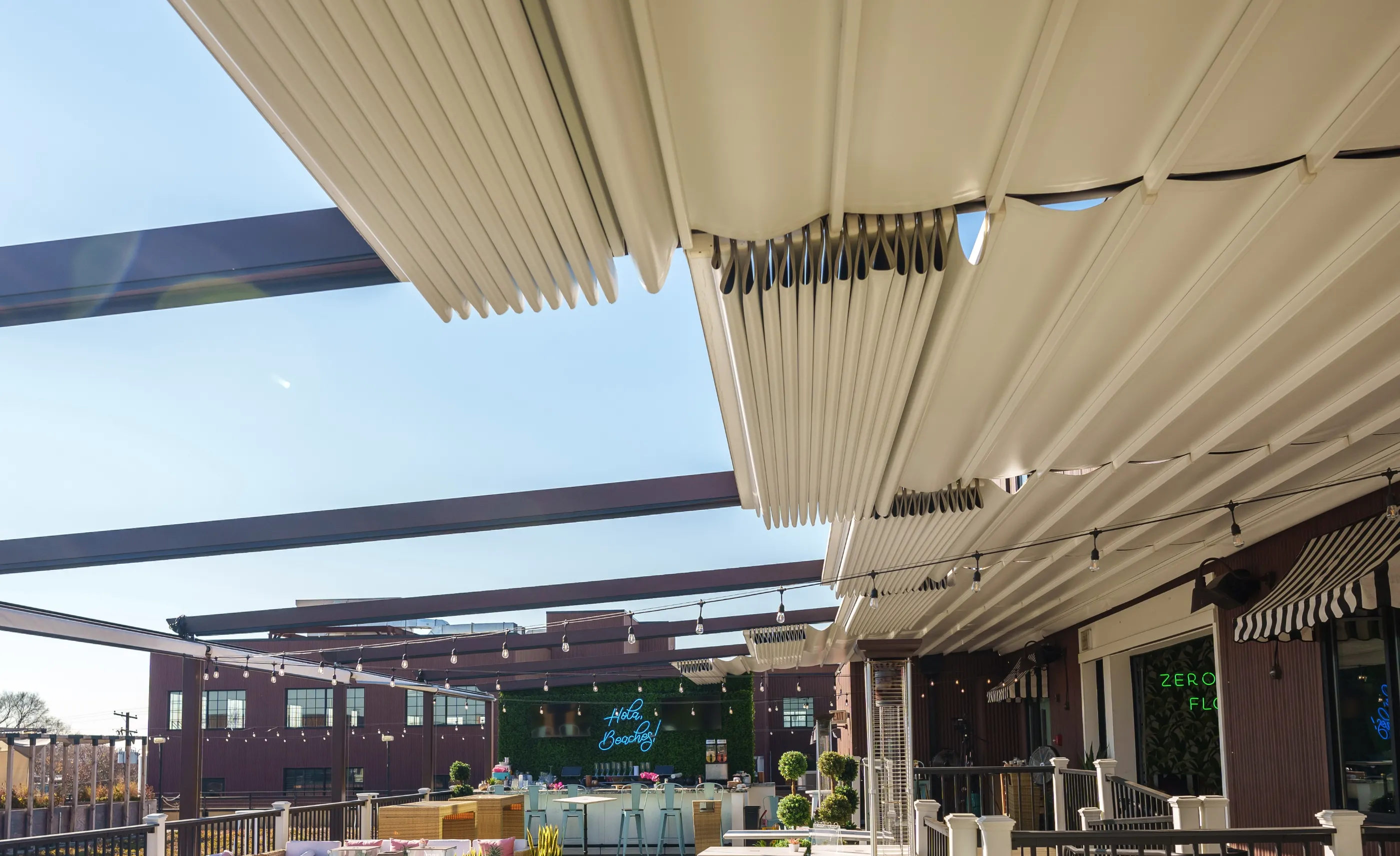 Featured image: Retractable pergola under clear skies with tables and chairs - Read full post: Retractable Pergolas for All Seasons: How to Use Them Year-Round