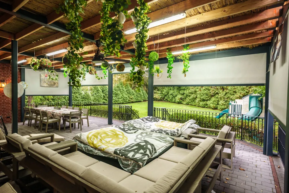 Featured image: A sukkah patio is shown with a swing, table, and chairs - Read full post: Sukkah Design Inspiration: How to Use Your Pergola to Create the Ultimate Sukkah Experience