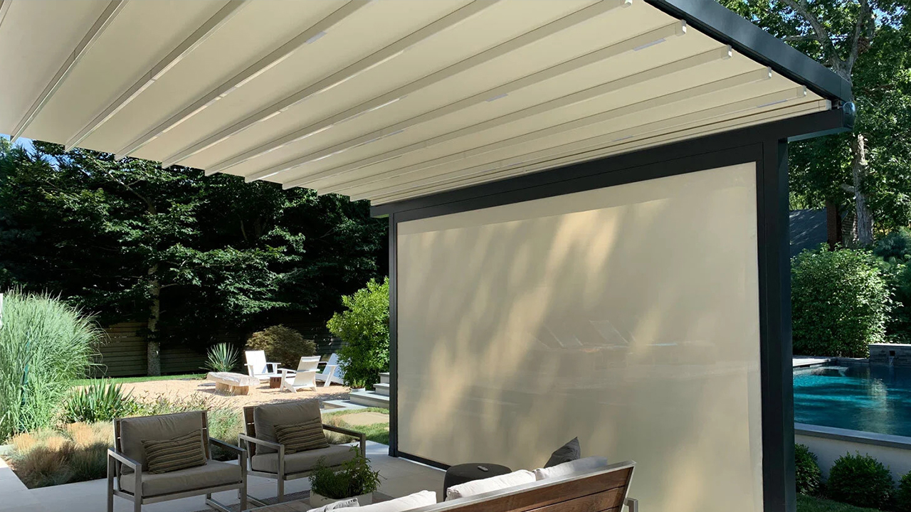 Featured image: A covered patio with chairs, a table and a sliding glass door - Read full post: Pergola Screen Options for Your Outdoor Privacy & Protection